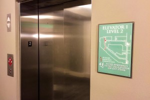 Aura Memorial Apartments Evacuation Sign with Map and ADA/Braille by Elevator