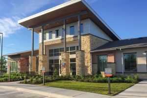 Villas on the Hill Apartments - Clubhouse Exterior with Colorful Signage